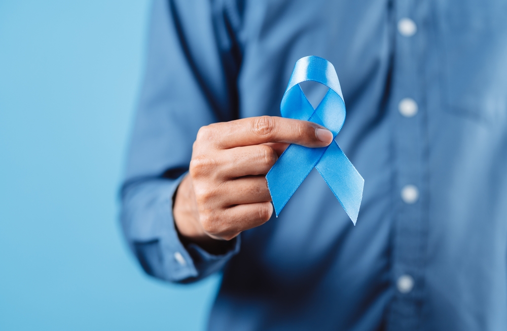 man holding blue ribbon.